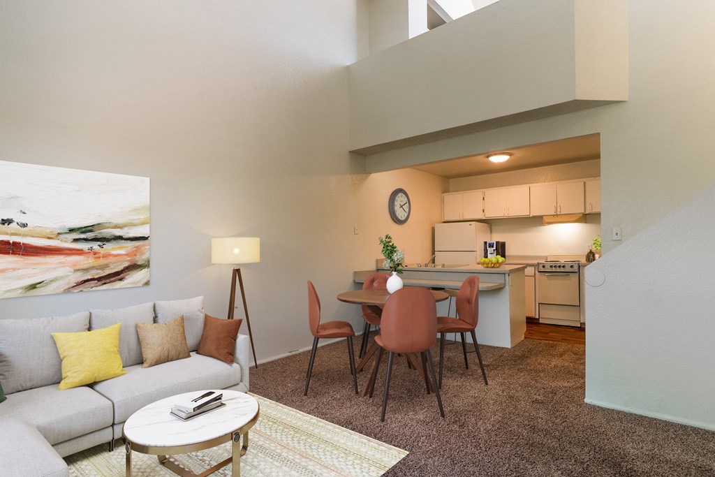 a living room with a couch and a table and a kitchen